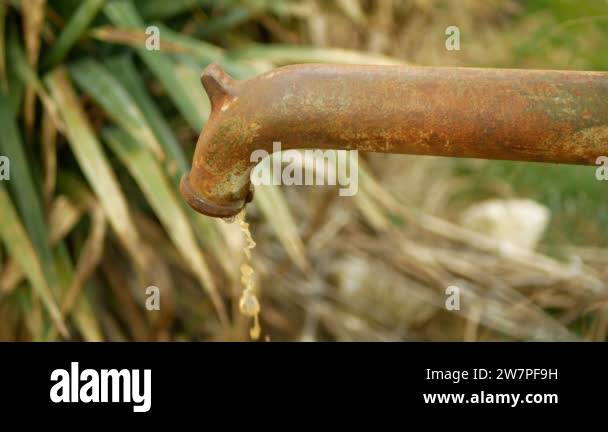 Dirty contaminated water spring water hand well pump outlet with dark