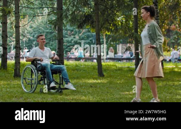 Friends spending time together - man in a wheelchair and his female ...