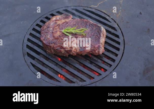 Rib Eye Steak With Spices On A Barbecue Grill Grate With A Blazing Fire