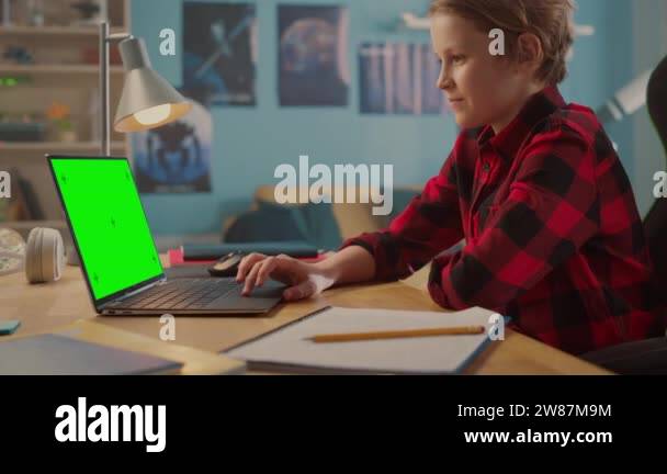 Young Boy Using Laptop Computer with Green Screen at Home Stock Video ...