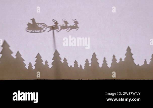 Puppet Shadow Theatre. Santa Claus on a sleigh with reindeer flies over ...