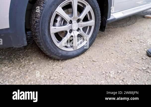 person placing wheel chocks under wheel of civil vehicle tire to ... - Asphalt Tire Changing With A Wheel Chocks