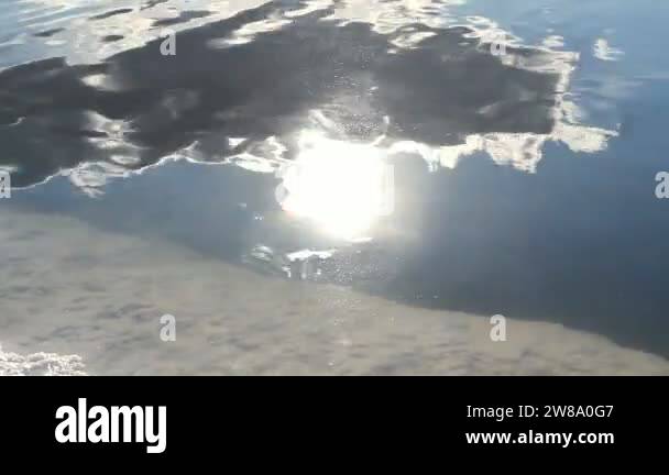 Sunny Reflection Reflection of the sunny sky with clouds in the salt brine lake ...