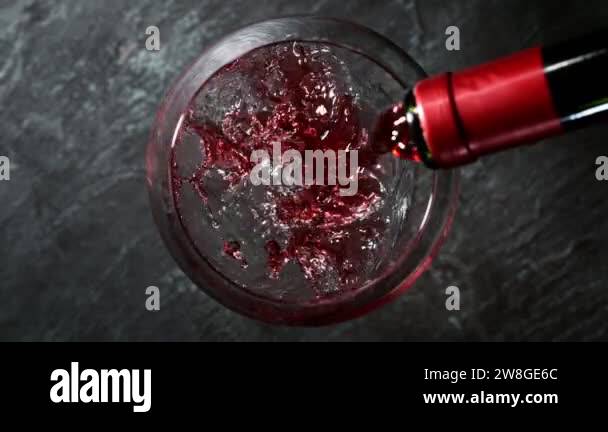 Super slow motion of pouring red wine into glass. Speed ramp effect ...