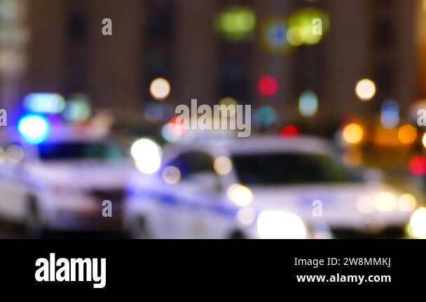 Blurry police cars with flashing lights at night, traffic patrol on a ...