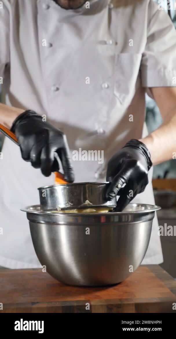 Cooking mashed potatoes. Chef passing boiled potato through sieve. Slow