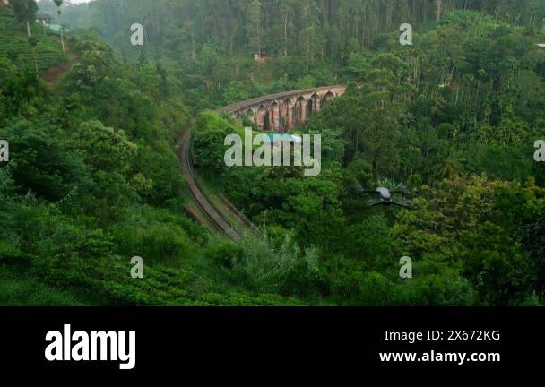 Train crosses iconic structure amongst scenic landscape, travel ...