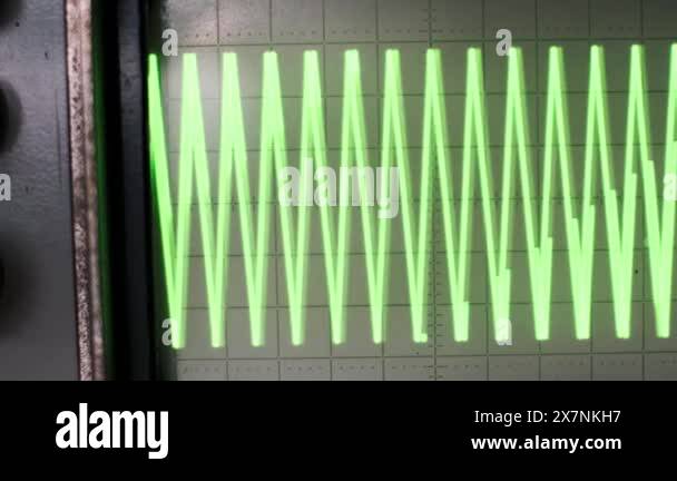 A vintage oscilloscope displays a dynamic green signal waveform ...