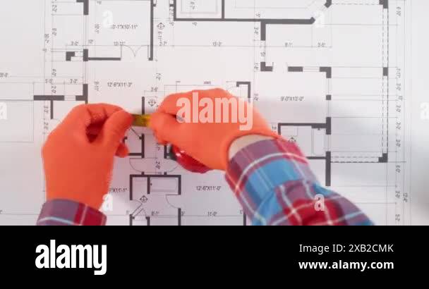 Engineer measures distance on apartment building floor plan with tape ...
