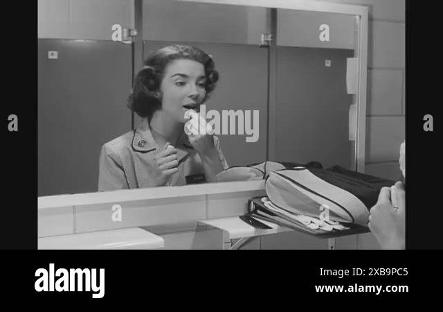 A private in the Women's Army Corps freshens up by applying lipstick ...