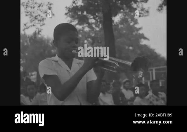 1940s - A young African-American boy plays the trumpet for a black