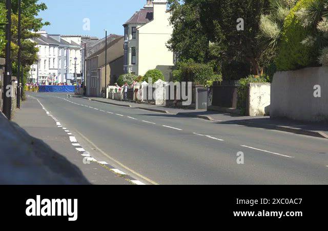 ISLE OF MAN- 8.27.2023 -Motorcyclists drive through a village in the ...