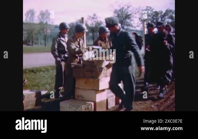 1945 - American soldiers pass out K rations to a passing line of Nazi ...