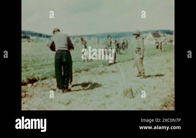 1945 - German POWs build barbed wire fences under the guard of an ...