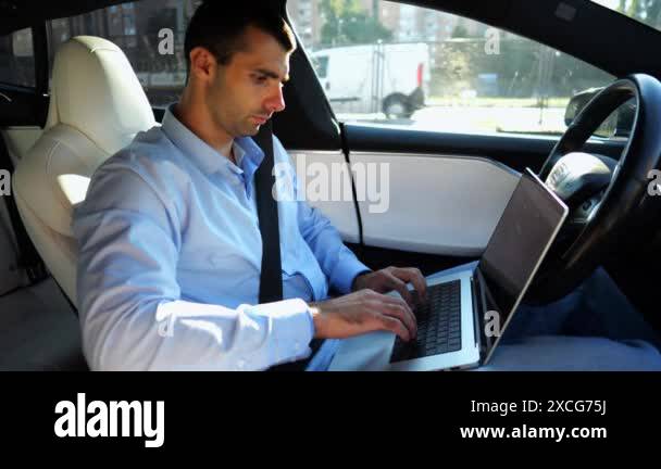 Handsome entrepreneur working on notebook while riding an autonomous ...