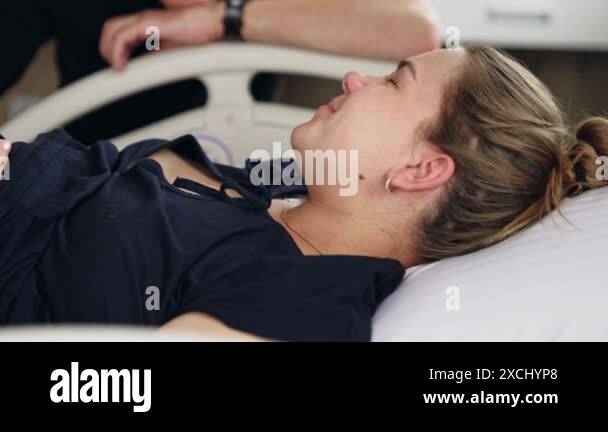 Fair-haired Caucasian woman lies in the hospital bed. Pregnant lady
