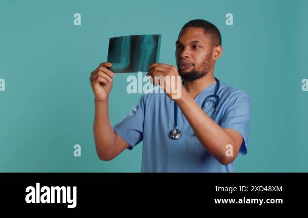 Male nurse analyzing radiology x ray scan to provide patient with ...