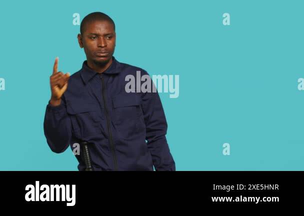 Portrait of security guard pointing finger at intruders while ...