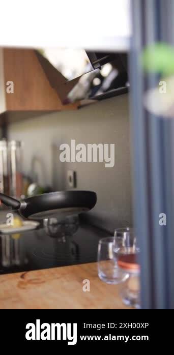 Contemporary kitchen with a stylish cooktop and organized glasses, creating a clean and elegant ...