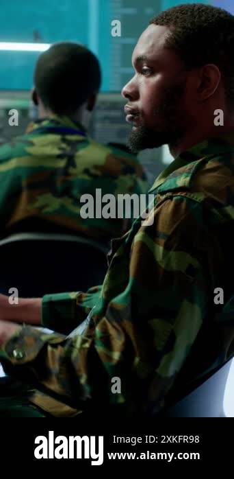 Vertical Video Military personnel in a high tech command center monitor ...