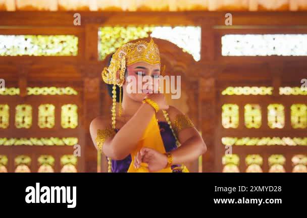 A woman in traditional attire performs a graceful dance in a ...