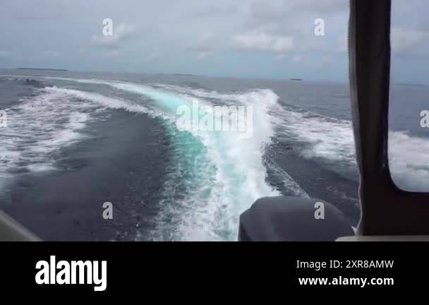 Waves from the engines of a speedboat. Rear view. Blue sky, white ...