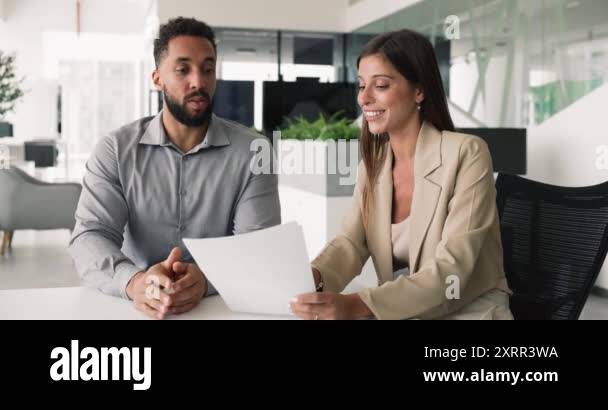 Two young multiethnic businesspeople, partners, client and manager ...