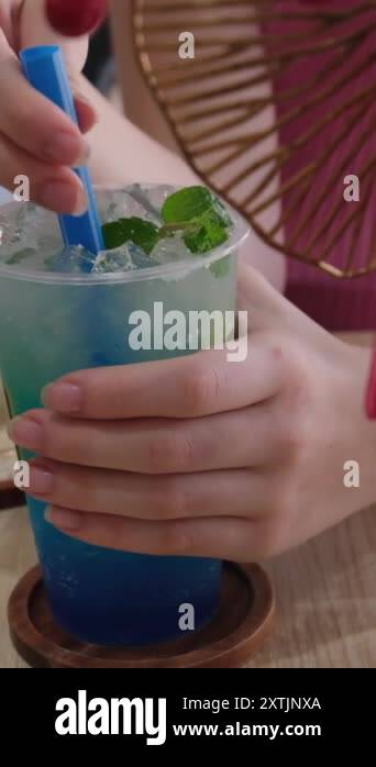 A rotating glass with lime lemonade and mint leaves and splashes from a ...