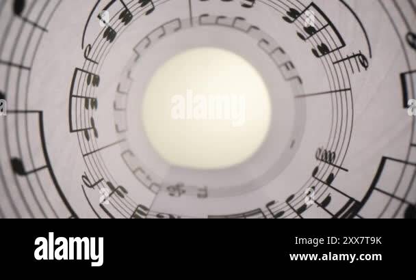 White paper with musical notes rolled up closeup and bright light ...