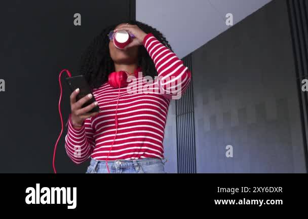 Young black female student in glasses smiling talking on mobile phone ...