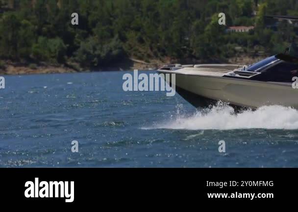 Motorboat is quickly moving on the water surface, leaving a trail of ...