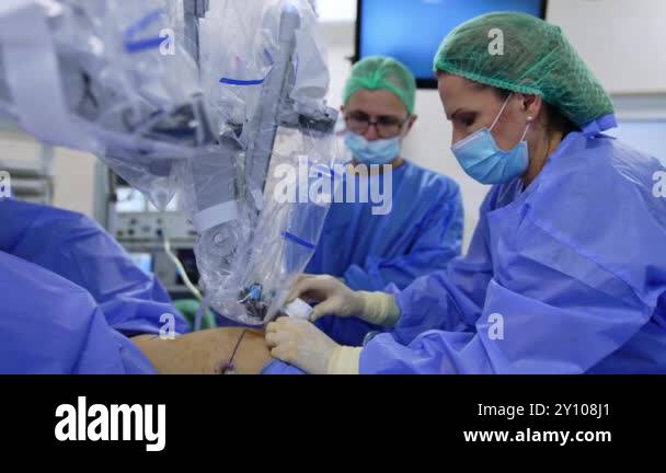 Female doctor attaches the robotic arm to the incision in patient's ...