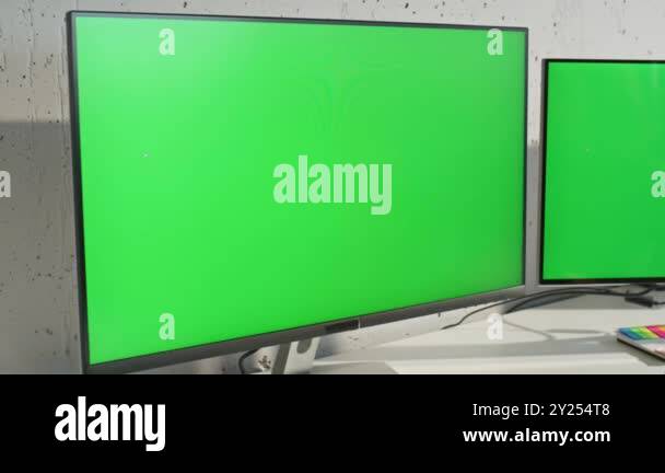 Two green screen monitors at light office table zoom out. IT woman ...