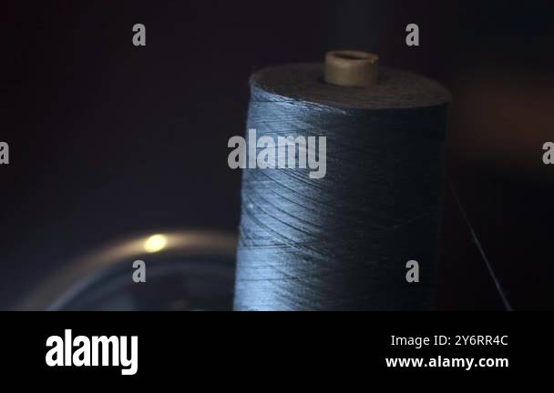 Process of sewing fabric. Closeup skein of black thread on a working ...