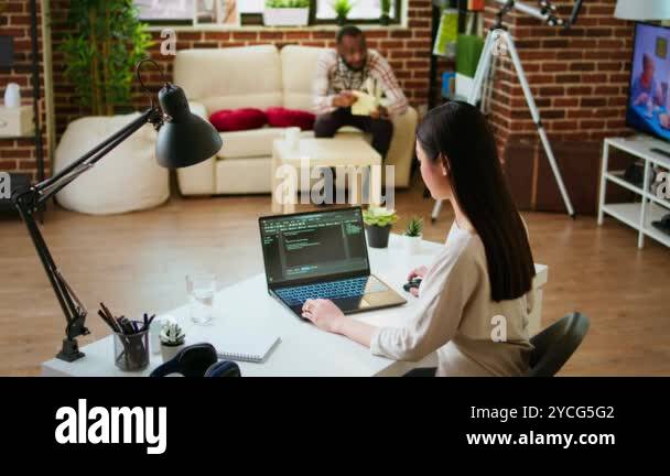 Software developer types programming code in a cozy home office setup ...