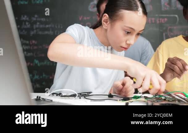 Diverse student using electronic tool fixing board while caucasian ...