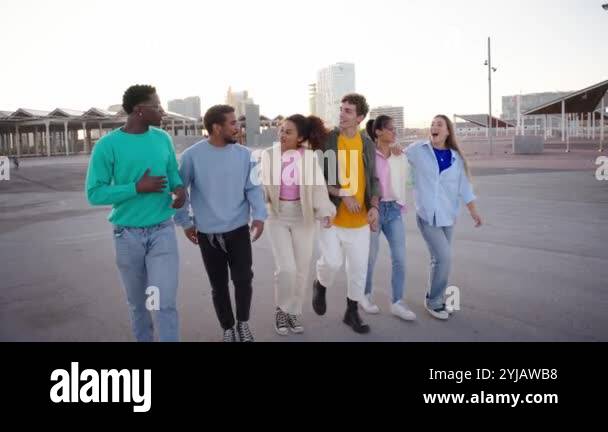 Group of young diverse friends walking relaxed and talking to each ...