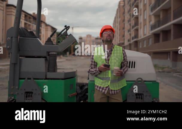 Construction worker on high-rise residential building site takes break ...