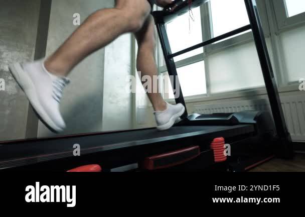 Cardio running training on a treadmill, close-up of a man's legs ...