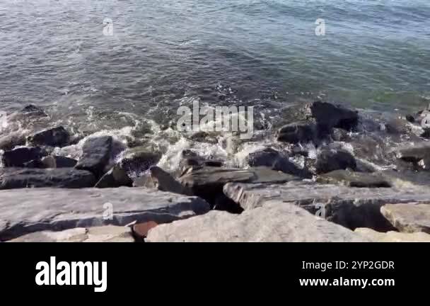 The gentle lapping of waves against the rugged rocks at twilight.A ...