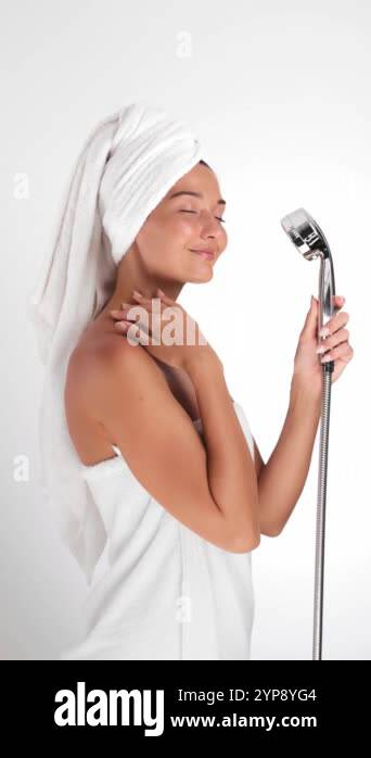 Shower Routine Towel And Robe Portrait of a woman smiling and holding a shower head, wrapped in a ...