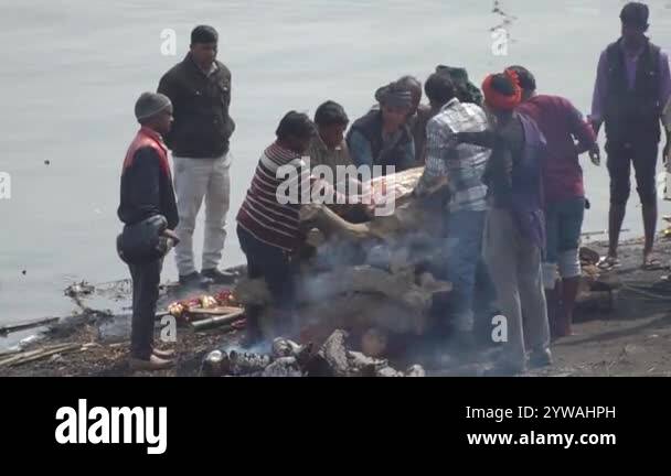 Men place the dead on the funeral cremation pyre at stairs of ...