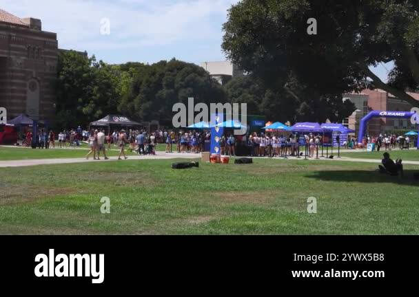 A bustling outdoor event at UCLA in Los Angeles features branded tents ...