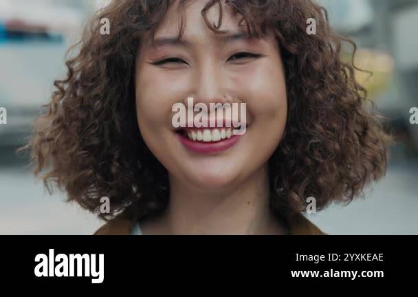 Portrait Of A Smiling Young Asian Girl With Curly Hair Standing Outside ...