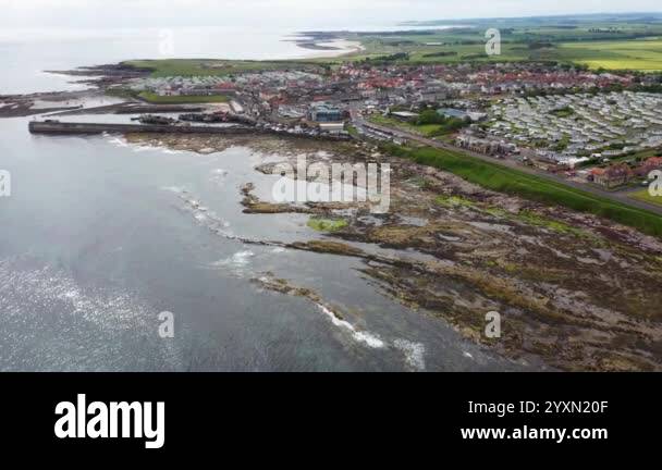 Aerial footage of the seaside coastal town of the village of Seahouses ...