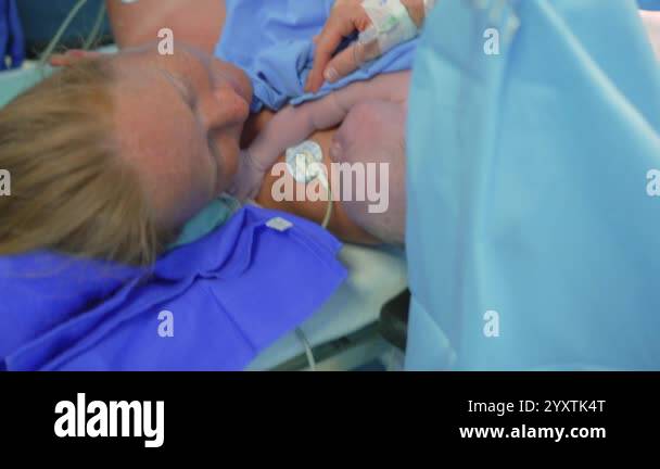 Born Operations A just-born baby is placed on the mothers chest as the surgeon ...