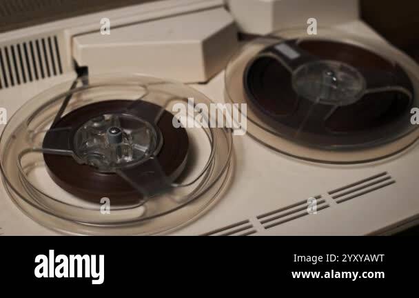 A detailed look at a spooling tape on a vintage reel-to-reel recorder ...