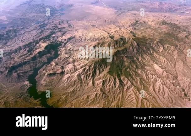 An aerial view of a vast, arid landscape with a winding river cutting ...