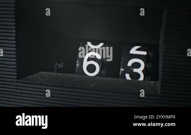 A detailed close-up of an old-fashioned number counter cycling from 61 ...