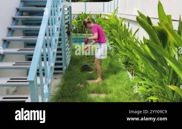 Woman Racking Lawn A young woman raking the lawn at the backyard of her house Stock Video ...
